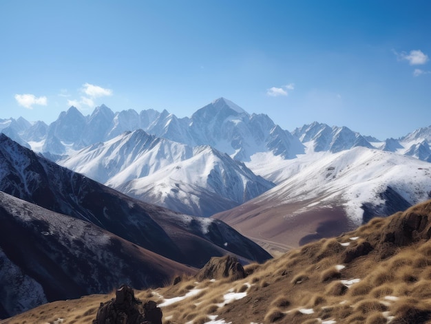 A mountain range with snow on the top and a blue sky in the background.