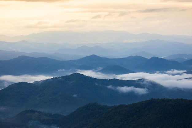 Mountain range with visible silhouettes through the morning colorful fog