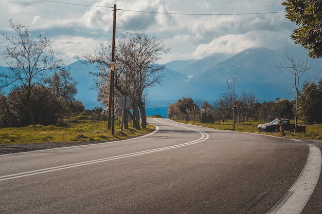 Mountain road Landscape with rocks sunny sky with clouds and beautiful asphalt road in the evening in summer Vintage toning Travel background Highway in mountains Transportation