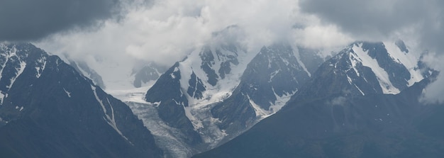 Mountain scenery snowcapped peaks in the clouds panoramic