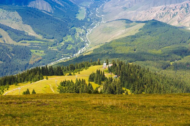 Mountain summer landscape Snowy mountains and green grass Peak Karakol Kyrgyzstan Beautiful view from the top of the mountain