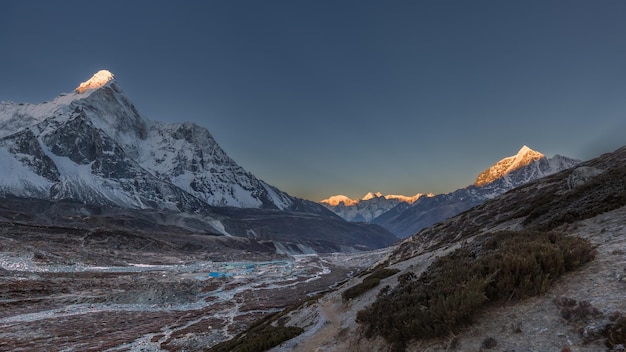 Mountain valley in Himalayas at dawn with sunlit tops of mountains Ama Dablam Chukhung Nepal