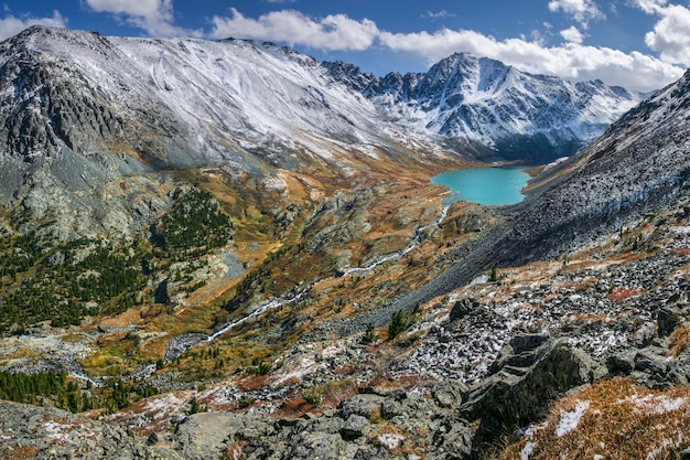 Mountain valley with a lake snowcapped peaks autumn