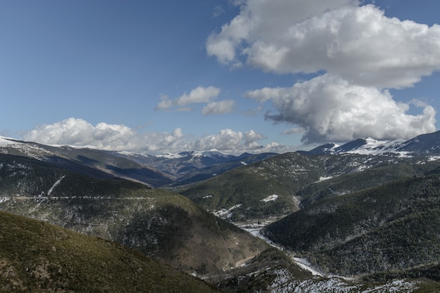 Photo mountain valley with some snow & big clouds