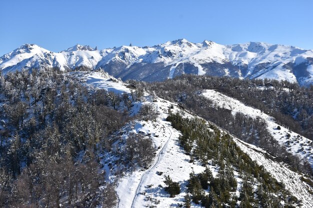 a mountain with a mountain in the background and a ski trail in the foreground