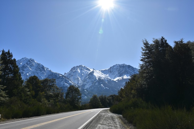 a mountain with snow on it and a sun shining on it