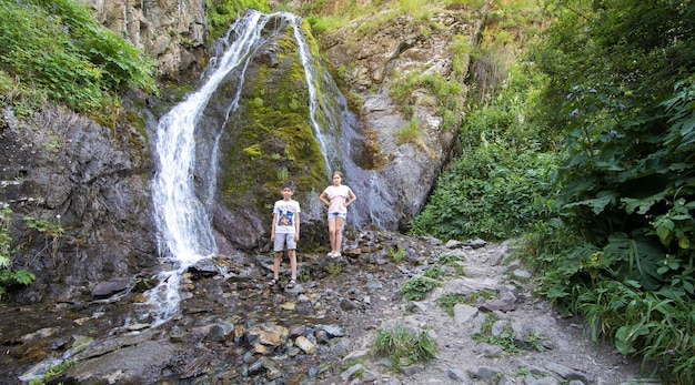 mountain wooded waterfall among the rocks in summer