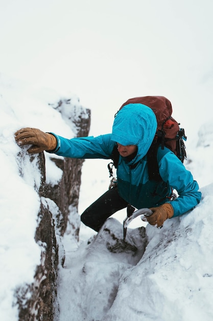 Mountaineer using an ice axe to climb Forcan Ridge in Glen Shiel, Scotland