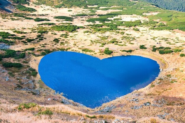 Mountains lake with blue water in a shape of heart