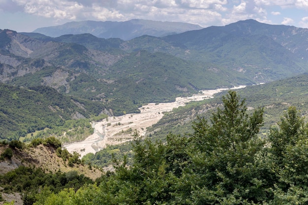 The mountains and the river Kalarrytikos Greeceon a sunny summer day