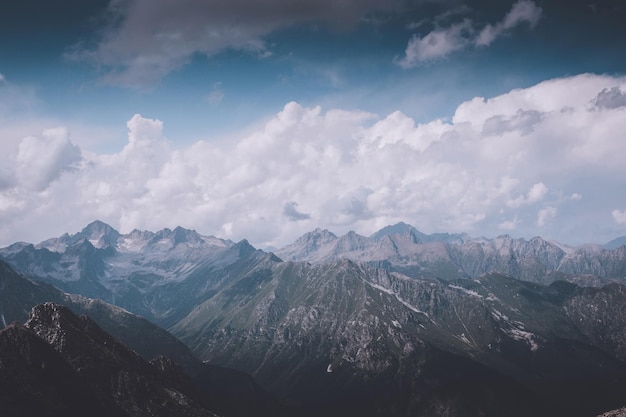 Mountains scene with dramatic cloudy sky in national park of Dombay, Caucasus, Russia. Summer landscape and sunny day