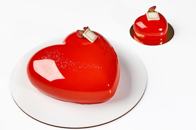 Mousse cake and pastry in shape of hearts with glossy red glaze