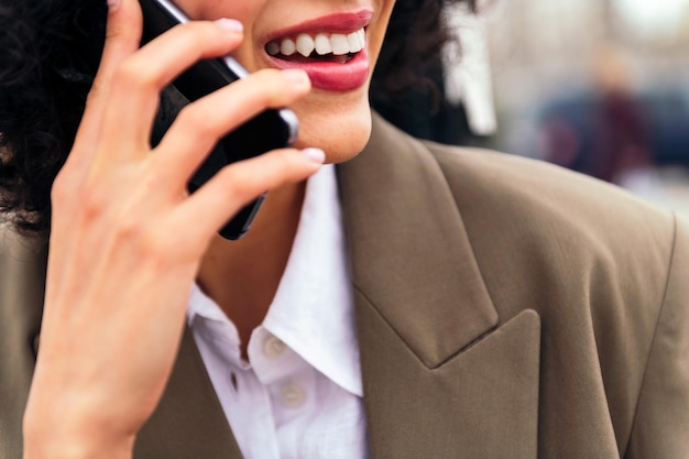 Mouth of a smiling woman talking by mobile phone