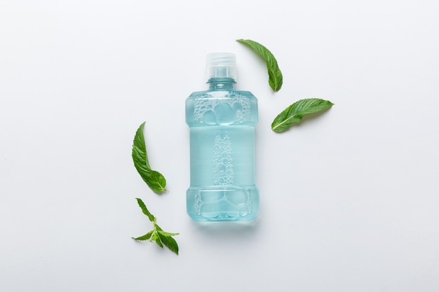 Mouthwash and fresh mint on colored background top view with copy space for text