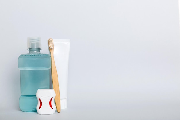 Mouthwash and other oral hygiene products on colored table top view with copy space Flat lay Dental hygiene Oral care products and space for text on light background concept