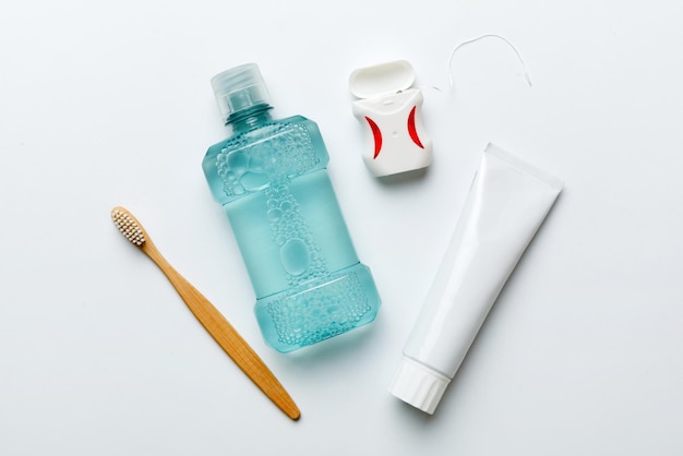 Mouthwash and other oral hygiene products on colored table top view with copy space Flat lay Dental hygiene Oral care products and space for text on light background concept