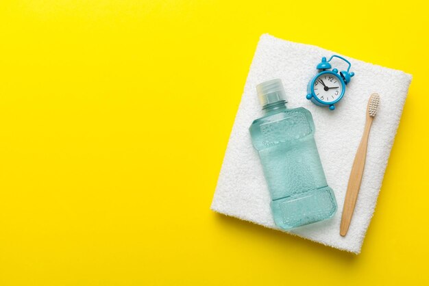 Mouthwash and other oral hygiene products on colored table top view with copy space Flat lay Dental hygiene Oral care products and space for text on light background concept