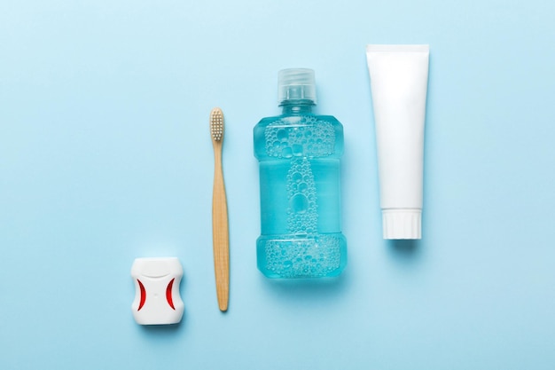 Mouthwash and other oral hygiene products on colored table top view with copy space Flat lay Dental hygiene Oral care products and space for text on light background concept