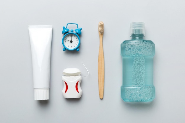 Mouthwash and other oral hygiene products on colored table top view with copy space Flat lay Dental hygiene Oral care products and space for text on light background concept