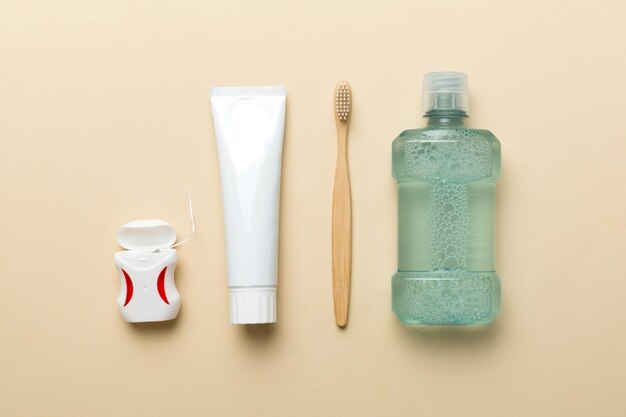 Mouthwash and other oral hygiene products on colored table top view with copy space Flat lay Dental hygiene Oral care products and space for text on light background concept