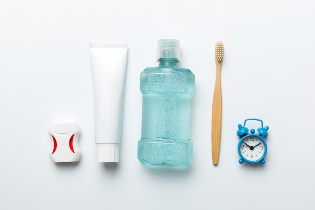 Mouthwash and other oral hygiene products on colored table top view with copy space Flat lay Dental hygiene Oral care products and space for text on light background concept