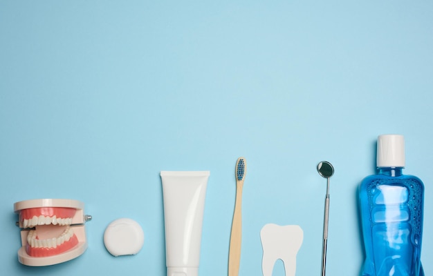 Mouthwash toothpaste tube dental floss and medical mirror on a blue background oral hygiene