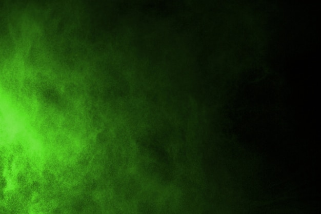 The movement of abstract dust explosion frozen green on black background. 