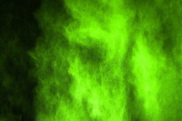 The movement of abstract dust explosion frozen green on black background. 