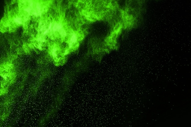 The movement of abstract dust explosion frozen green on black background. 