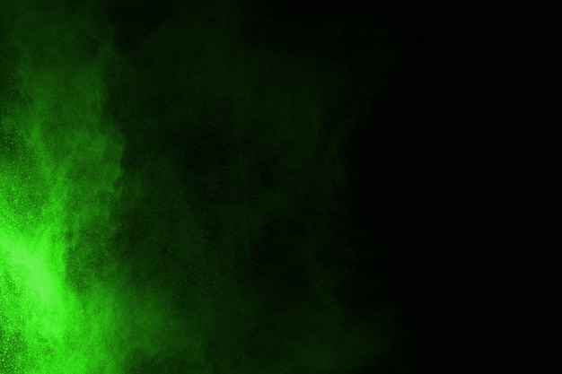 The movement of abstract dust explosion frozen green on black background. 