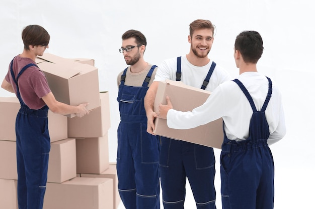 Movers lifting stack of cardboard moving boxes isolated on white