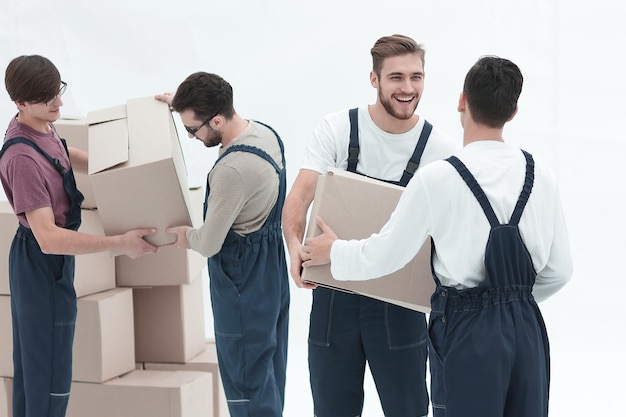 Photo movers lifting stack of cardboard moving boxes isolated on white