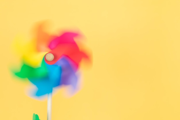 Moving coloured pinwheel on yellow background Copy space Thematic lgtbq