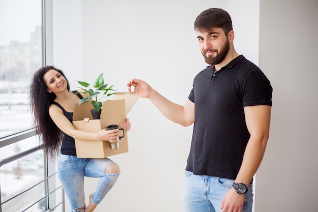 Moving day. Happy young couple carrying boxes