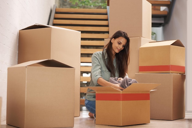 Moving on to greener pastures Young woman packing up boxes in an apartment