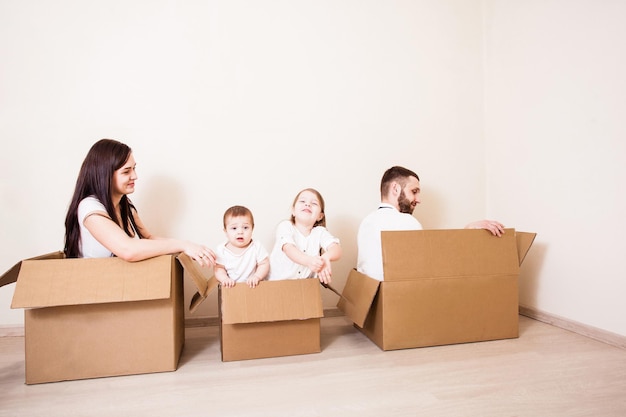 Moving house day and family games in cardboard boxes at new home