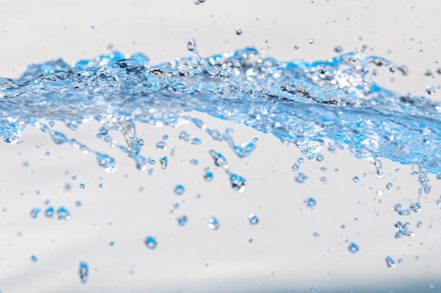 Photo moving water with droplets in studio with white background spash