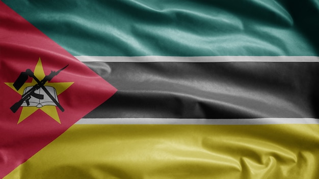 Mozambican flag waving on wind. Close up of Mozambique banner blowing, soft and smooth silk.