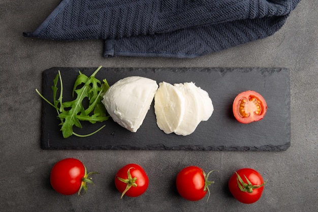 Mozzarella tomatoes and fresh salad Concrete grey background