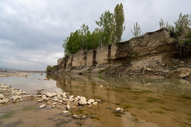 A muddy river with green vegetation on the shore