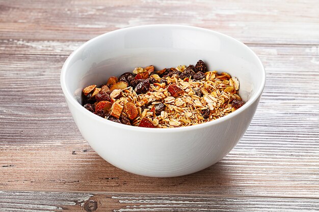 Muesli in the bowl on wooden table