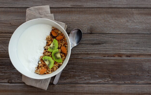 Muesli with white yogurt, kiwi and coconut flakes