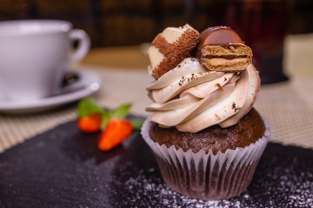 Muffin cake with chocolate and strawberries closeup