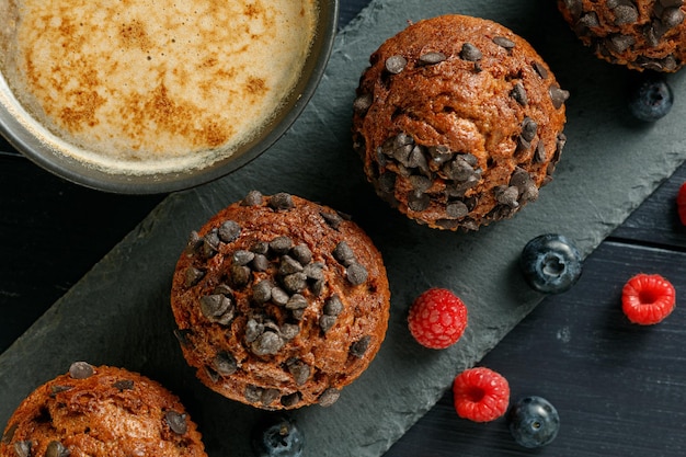 Muffins chocolate cupcakes with cappuccino and berries