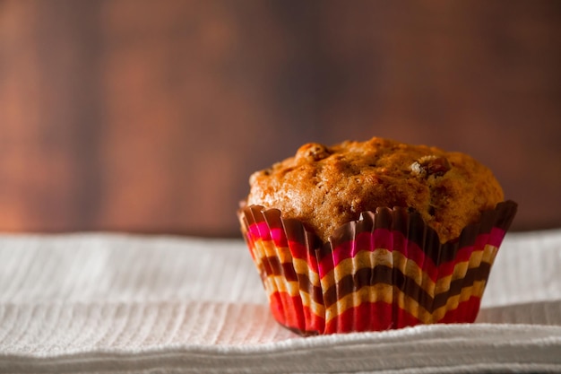 Muffins with raisins on a wooden background Cupcake in a paper mold on a white napkin