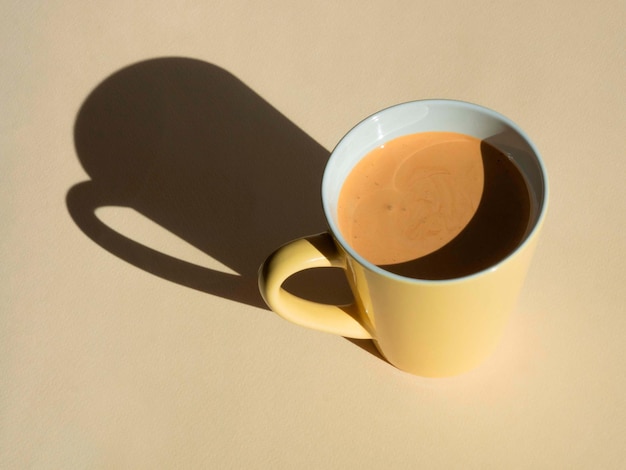 Mug of cappuccino coffee on beige with harsh shadows in hard light Minimalism natural colors