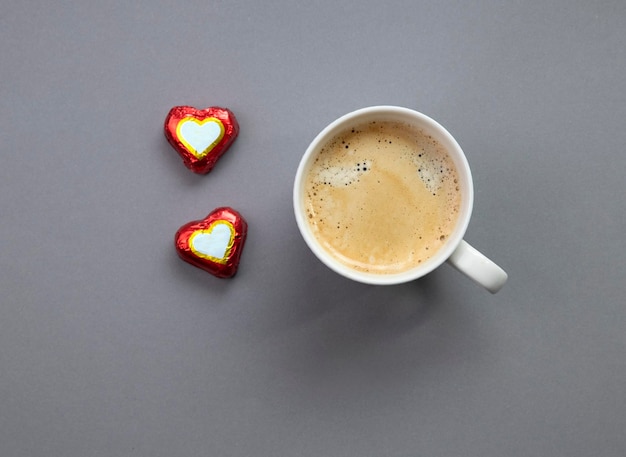 mug of coffee and candy hearts on gray background