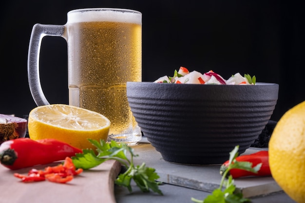 A mug of cold beer and a bowl of ceviche.