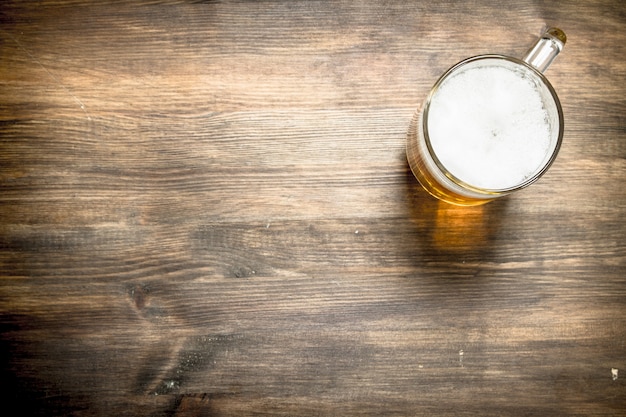 Mug of fresh beer on a wooden table