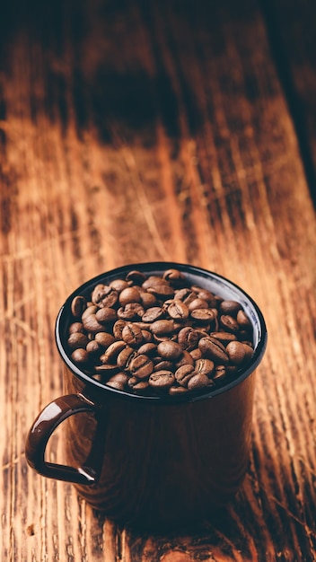 Mug full of roasted coffee beans